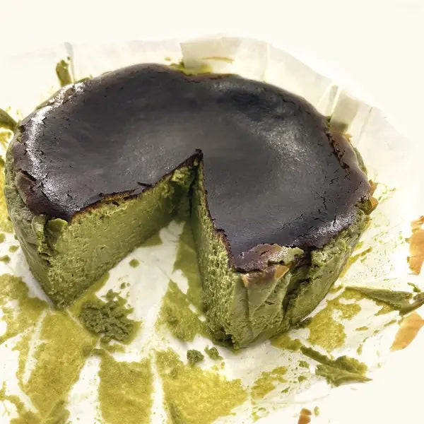 Matcha Burnt Cheesecake with a wedge cut out, deep green inside
