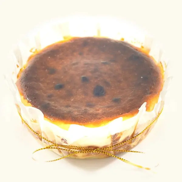 Whole Molten Burnt Cheesecake in fluted parchment with gold string