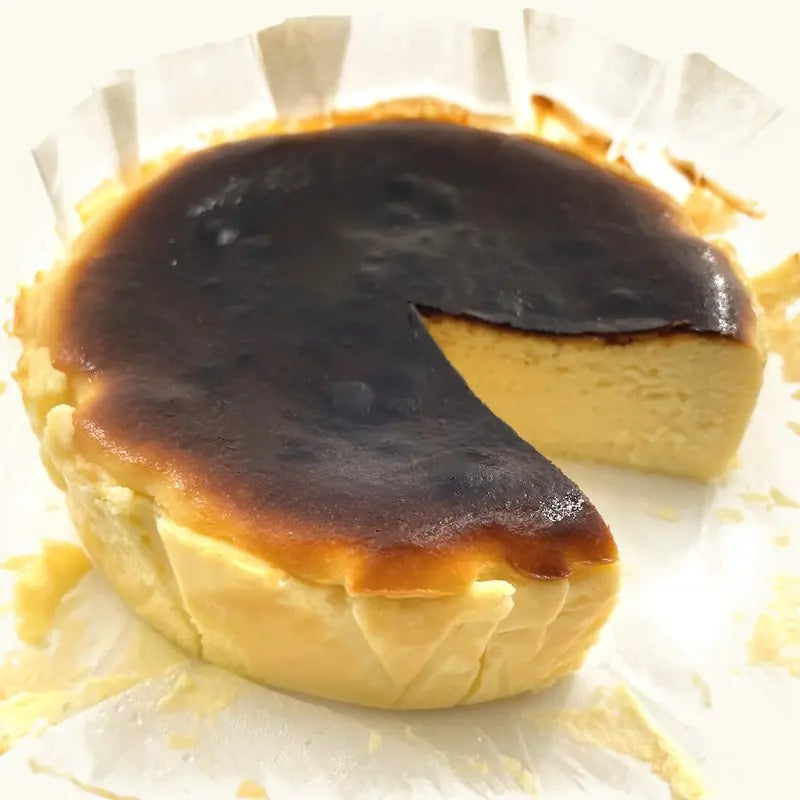 Original Burnt Cheesecake with a wedge cut out, showing the creamy yellow inside