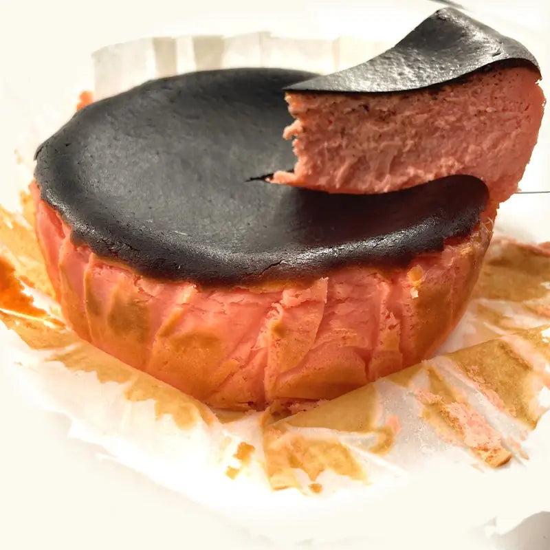 Strawberry Burnt Cheesecake with a slice lifted out, pink inside