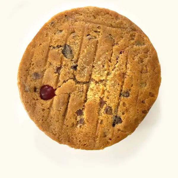 The Alcoholic Fruit Cake from above: a scored golden top studded with fruit and a glacé cherry