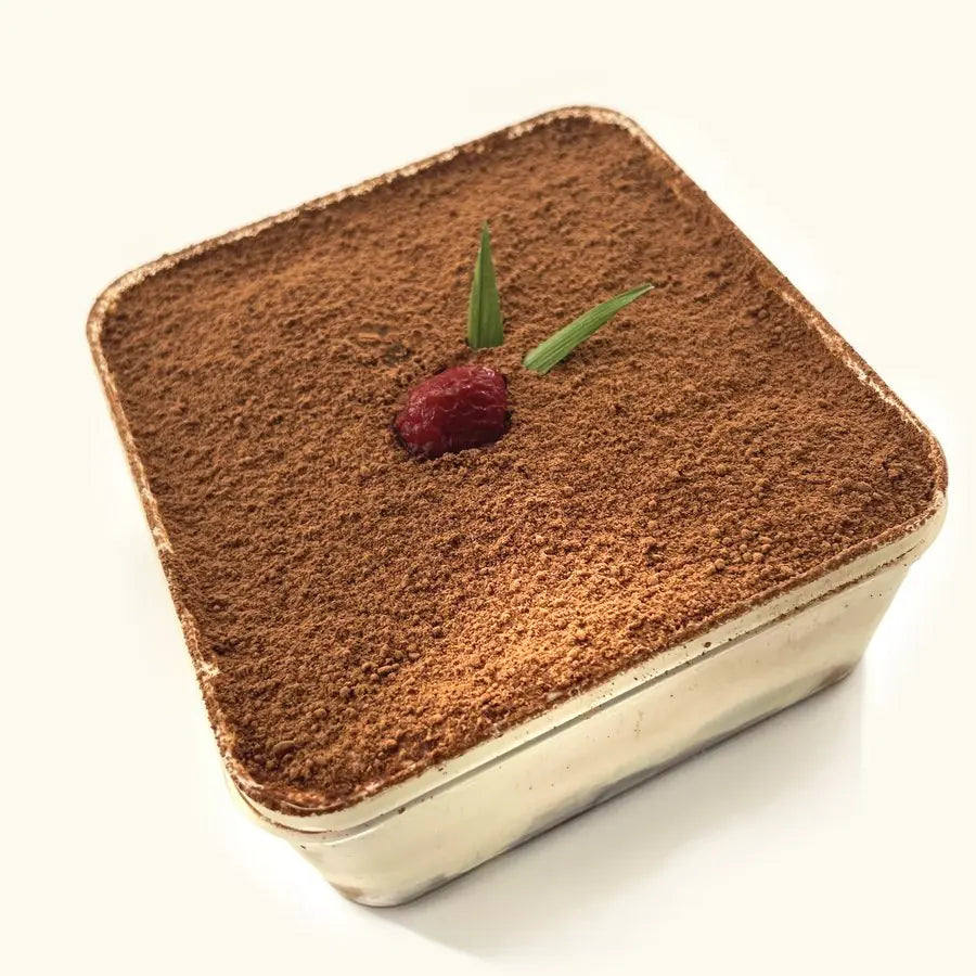 Premium Tiramisu in its clear tub, dusted with cocoa and topped with a raspberry