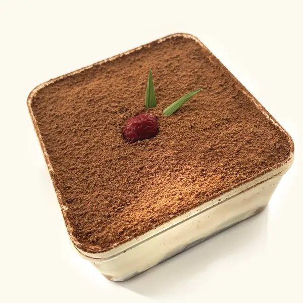 Premium Tiramisu in its clear tub, dusted with cocoa and topped with a raspberry