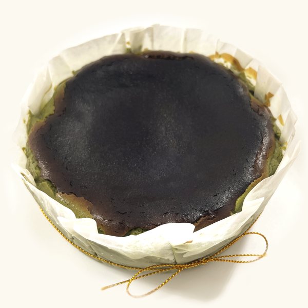 Whole Matcha Burnt Cheesecake in fluted parchment with gold string