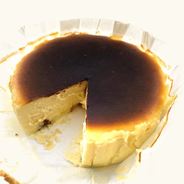 Rum and Raisin Burnt Cheesecake with a wedge cut out, raisins in the creamy inside