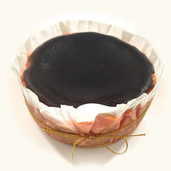 Whole Strawberry Burnt Cheesecake in fluted parchment with gold string, pink sides