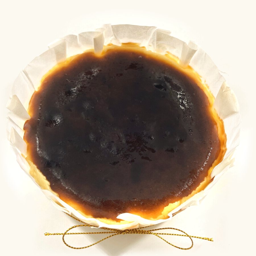 Whole Original Basque Burnt Cheesecake in fluted parchment with gold string