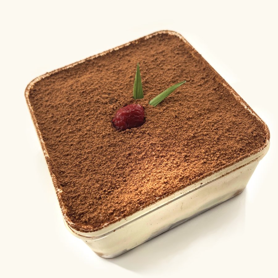 Premium Tiramisu in its clear tub, dusted with cocoa and topped with a raspberry